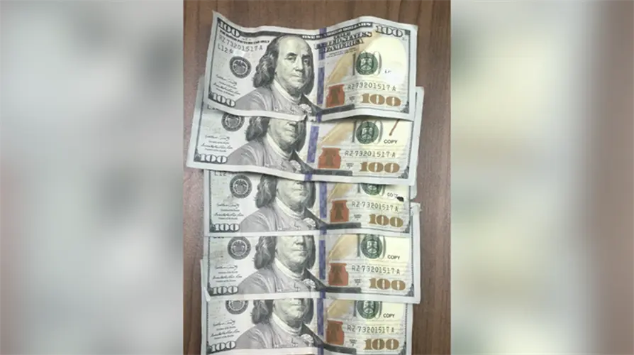 Authorities say woman found with counterfeit bills