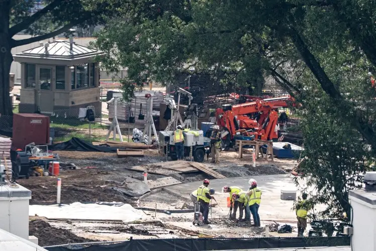 Crews remove the granite seal on the White House helipad, signaling potential project delays