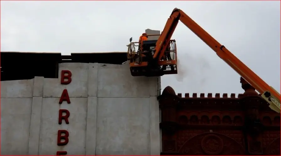 Front of Barber Building starts to come down