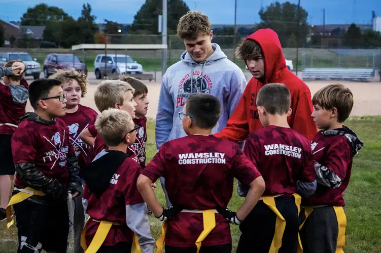 Sidney football players answer call to coach next generation